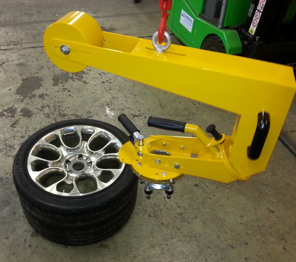 Ein gelbes Lastaufnahmemittel zum Aufnehmen der Felge mit Reifen eines Bugatti Veyron.